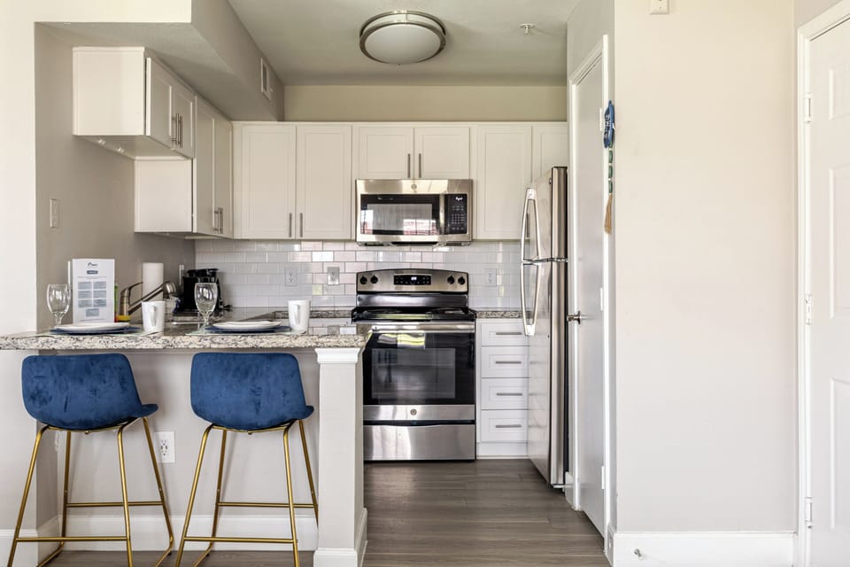Modern kitchen with breakfast bar, stainless appliances, and stylish seating