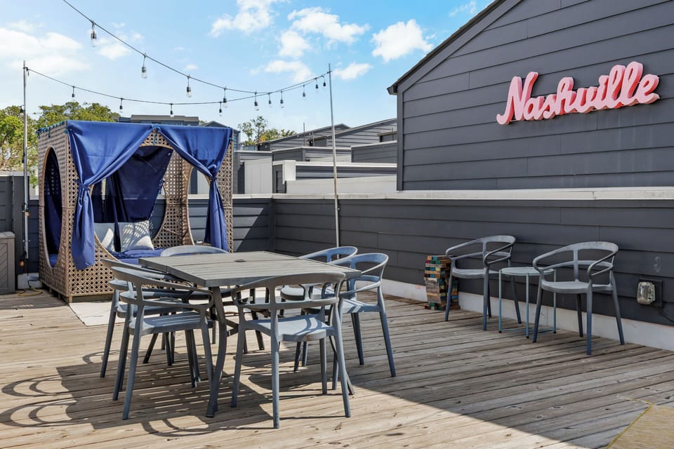Private rooftop deck with cabanas, dining space, and string lights.