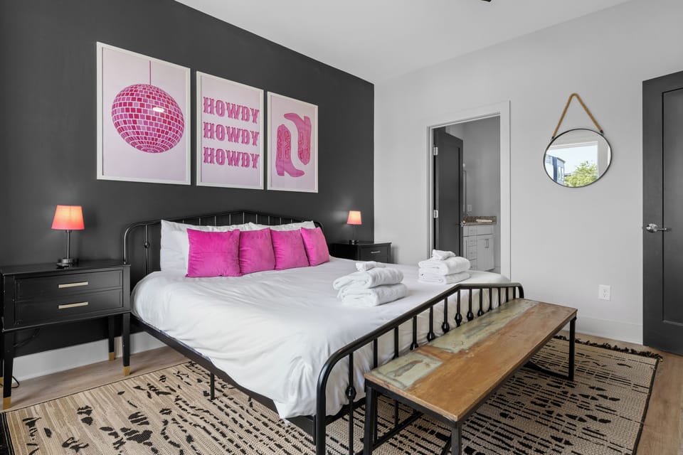Inviting bedroom with a plush king bed and vibrant pink accents.