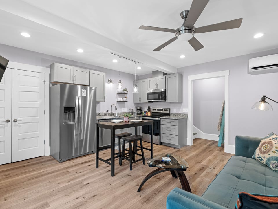 Bright modern studio with sleek kitchen, island seating, and cozy lounge area
