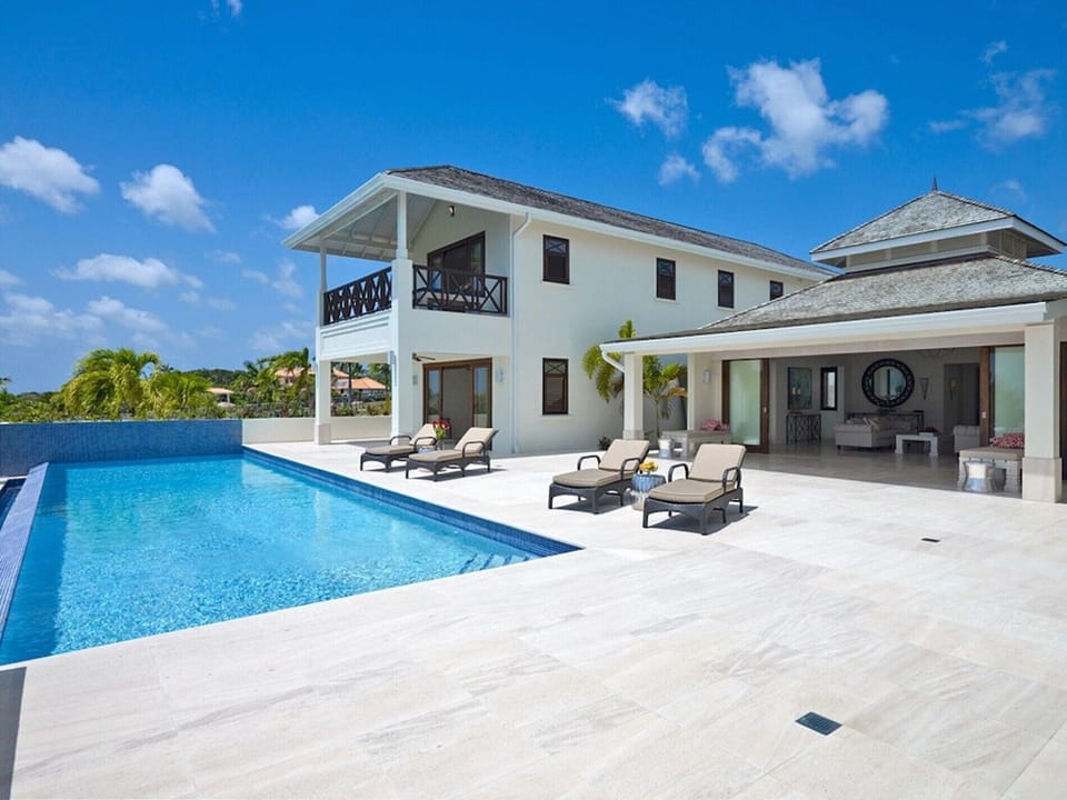 Terrace with infinity pool, sun loungers, and covered lounge overlooking ocean