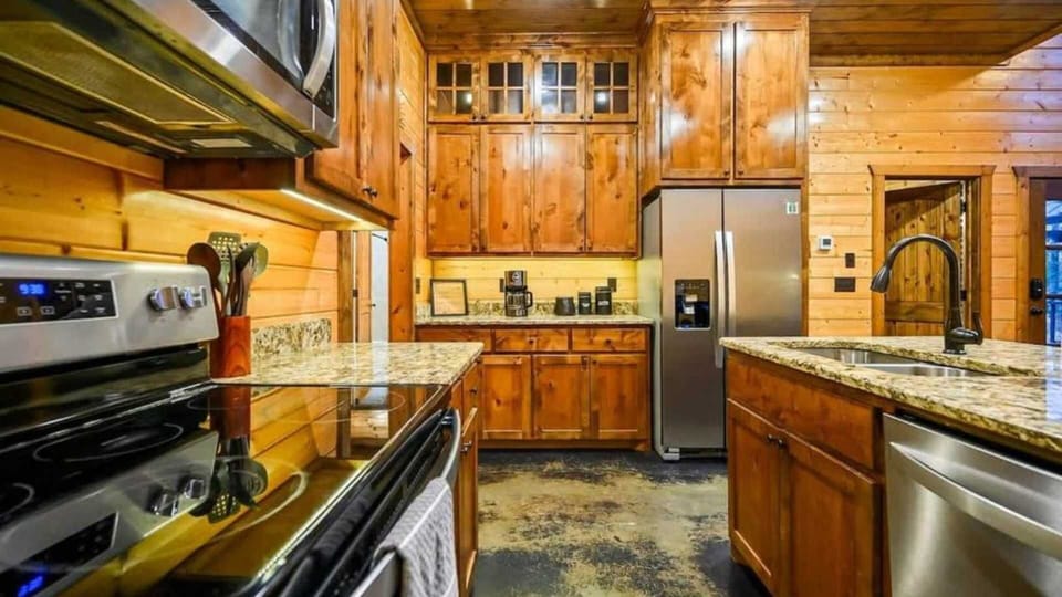 Fully equipped kitchen with stainless appliances and rich wood cabinetry.
