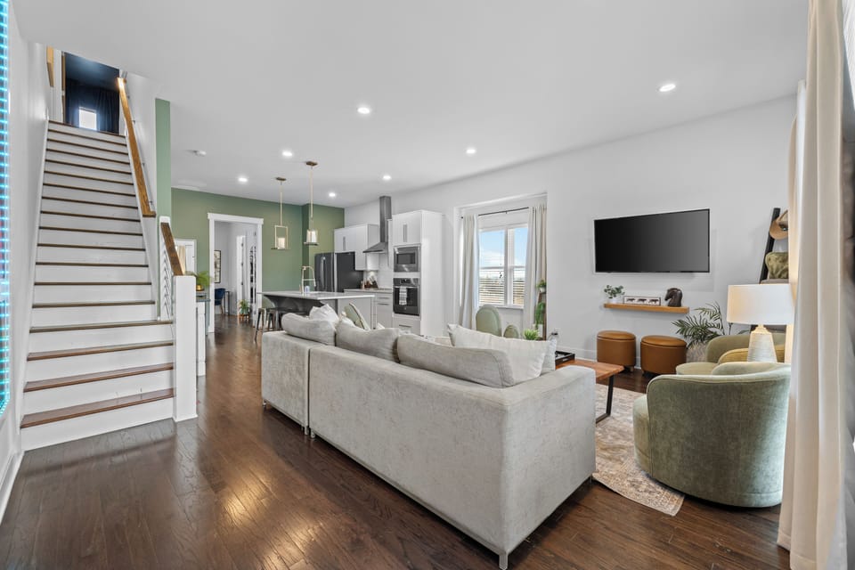 Bright open-plan living with sleek kitchen, hardwood floors, and balcony doors.
