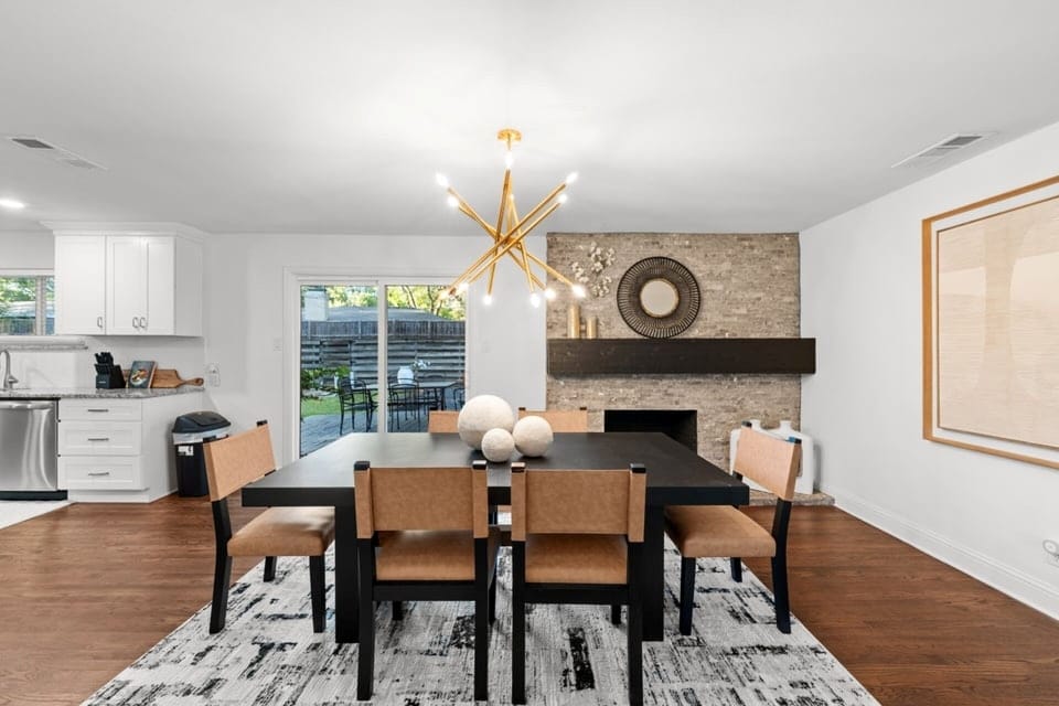 Modern dining space with statement lighting and fireplace backdrop, perfect for shared meals, remote work lunches, or hosting during your Dallas stay. Convenient access to Addison restaurants, shopping centers, and major highways nearby.