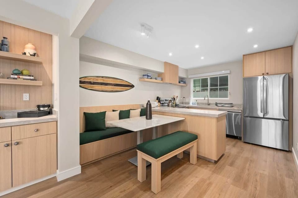This modern coastal kitchen features top-of-the-line stainless steel appliances, including an LG refrigerator, built-in microwave, electric stovetop, and dishwasher, everything you need for a seamless stay.