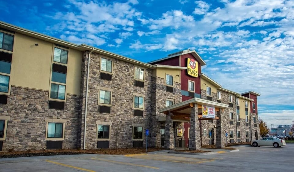 Arrive to a bright, inviting hotel exterior under open skies.