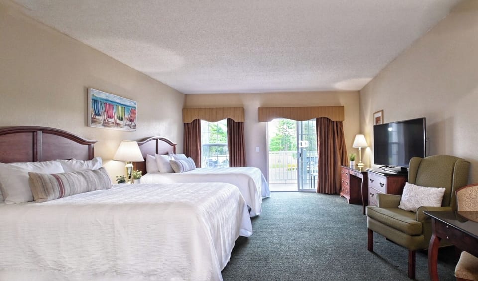 Unwind in airy double-queen comfort with balcony daylight.