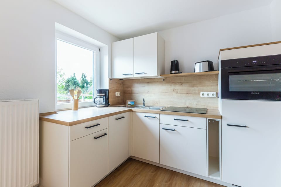 Modern kitchen with white cabinets and wooden surfaces