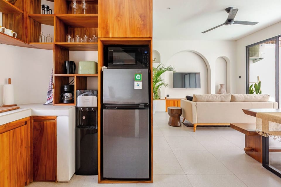 Kitchen with coffee maker, tea kettle toaster, microwave, water dispenser.