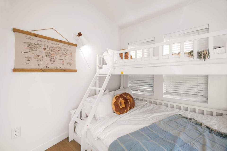 Twin-over-queen bunk bed with cozy bedding and playful décor for little travelers.
