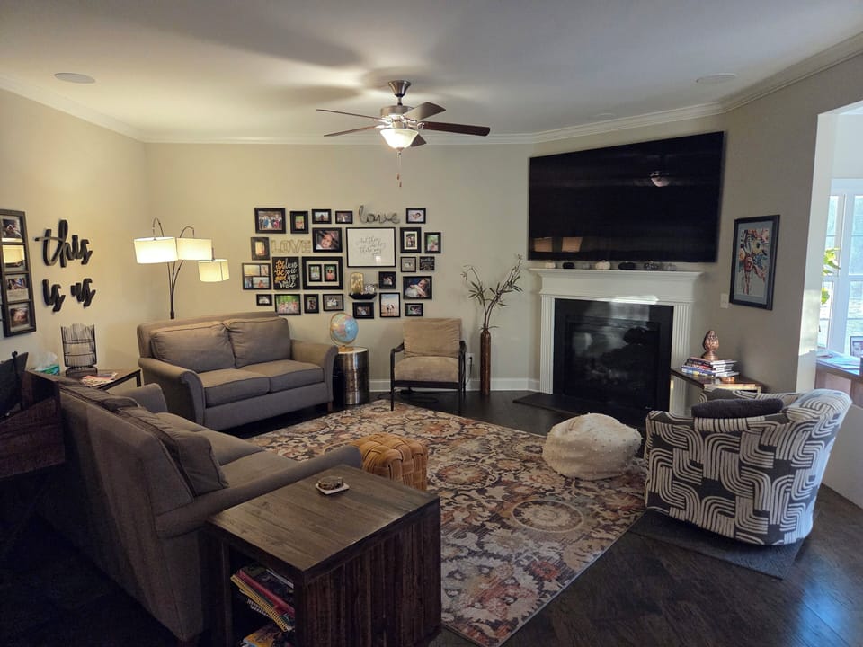 Living room has plenty of seating, an 85" TV, and gas fireplace.
