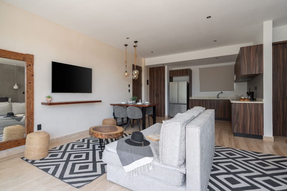 Bright open living area with balcony, smart TV, and chic décor