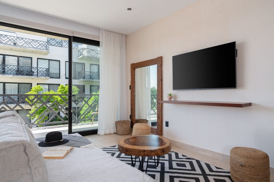 Bright living space with soft tones, balcony access, and cozy modern décor
