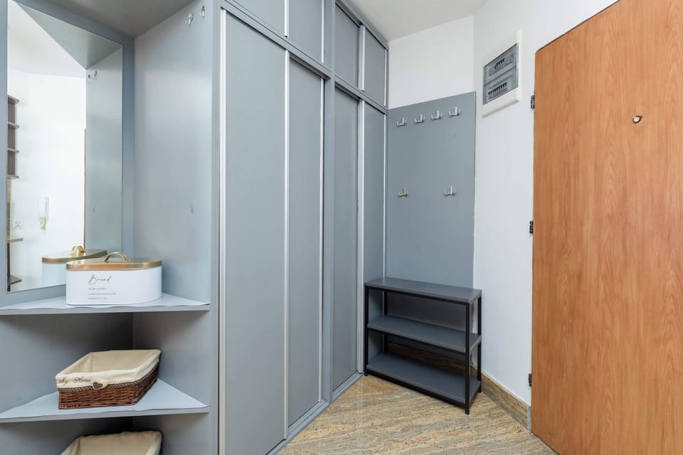 A hallway with built-in wardrobes and mirrors. The clean lines and neutral tones make it both functional and visually appealing.
