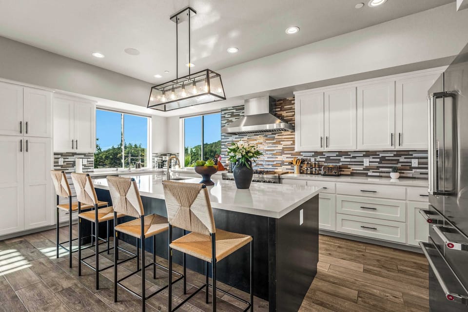 Bright, modern kitchen with a large island, sleek appliances, and bar seating for easy breakfasts or evening hangouts. Sunlight fills the space, making cooking and gathering feel relaxed and fun—perfect for families and friends.