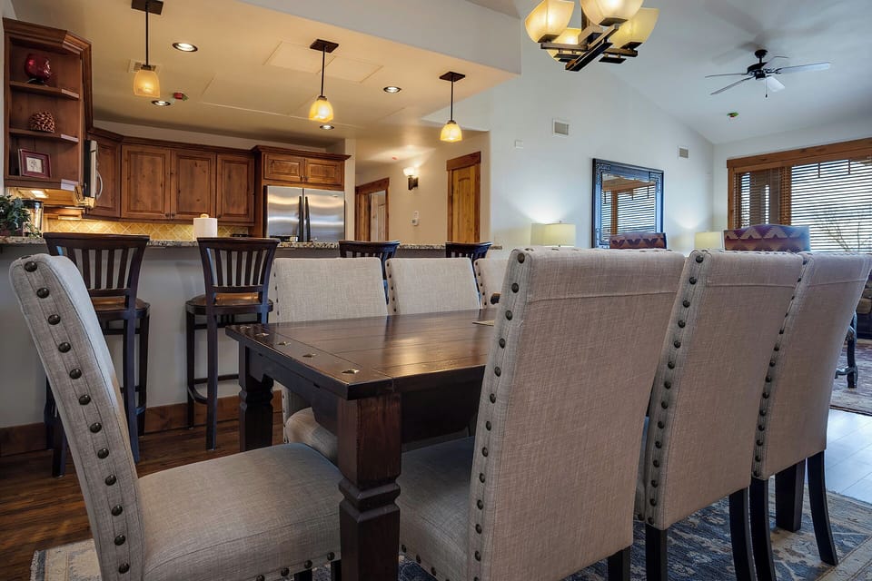 Gather around this elegant dining table for memorable meals, with warm pendant lighting creating the perfect ambiance for your group dinners.