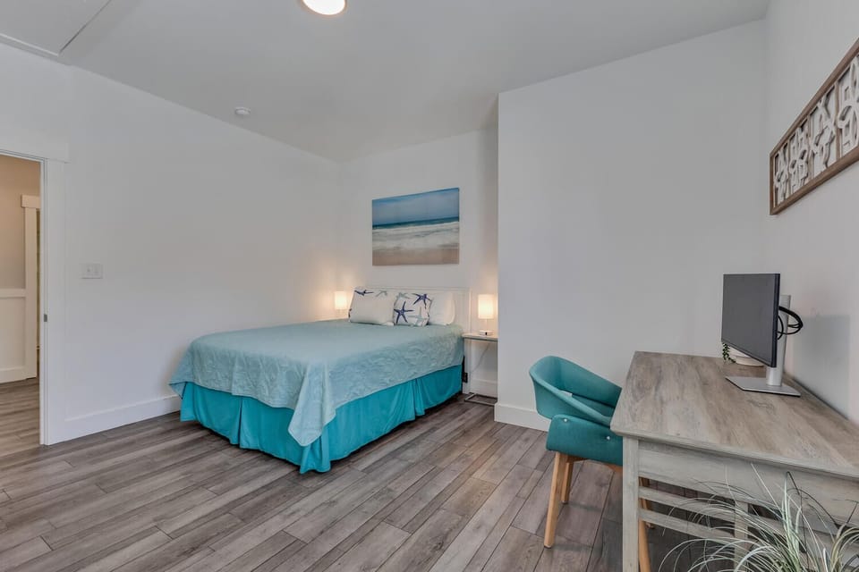 Drift into peaceful dreams in this coastal-inspired bedroom, complete with comfortable seating and workspace for your perfect getaway.