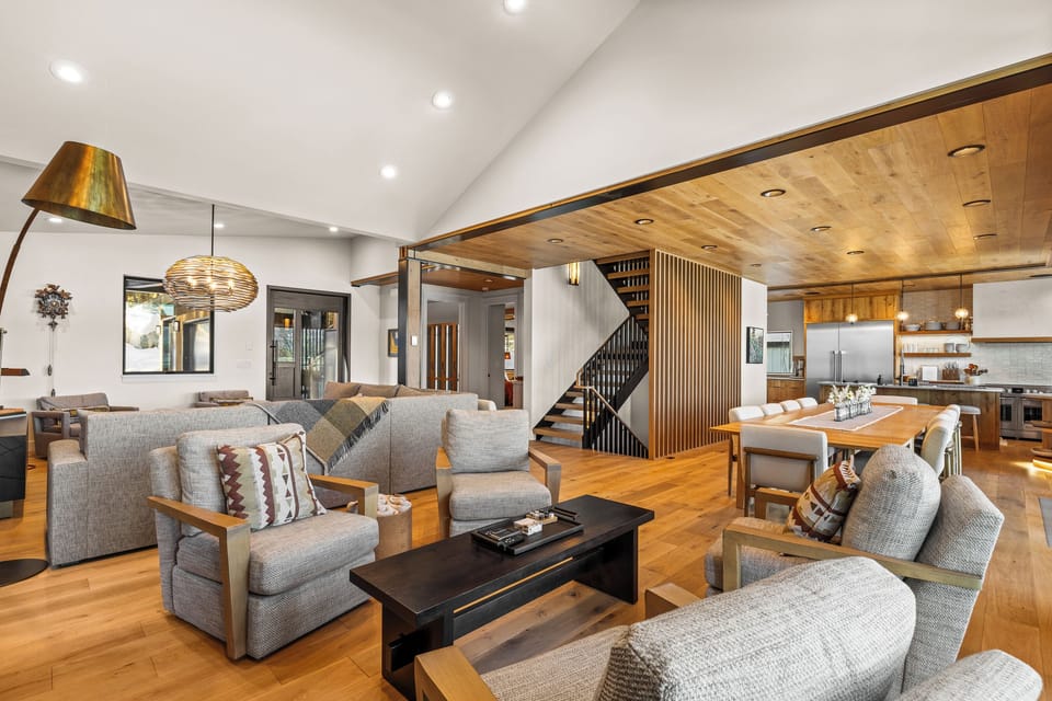 This open concept main floor living space is a dream, offering access to the garage, mudroom/laundry room, dining area, kitchen, balcony, a powder room, and the primary bedroom. Did we mention the views???