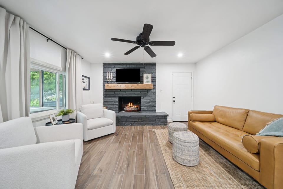 The great room is an open floor plan with with a sofa and two swivel arm chairs.