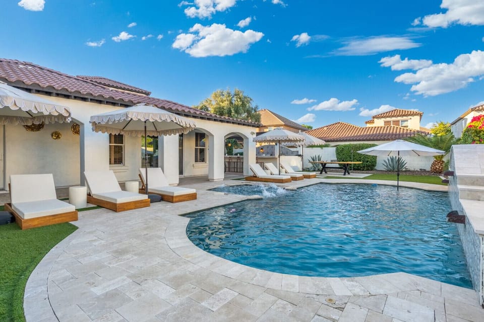Sunlit courtyard pool framed by stone & tile, perfect for refreshing dips under clear skies