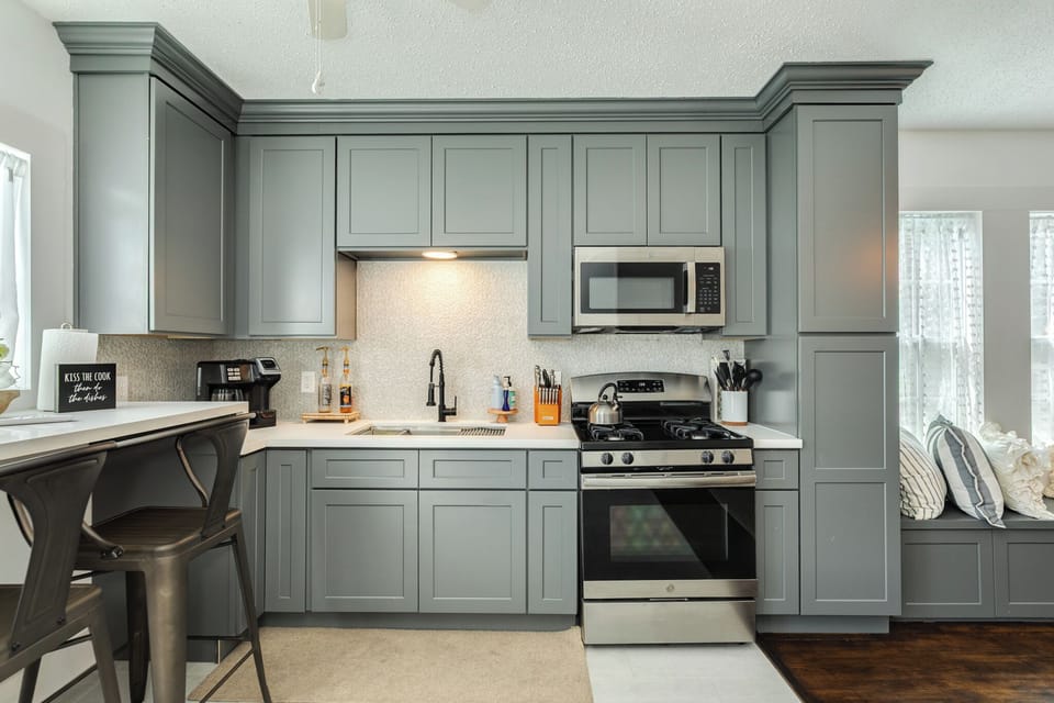 Bright, well-equipped kitchen with modern cabinets and cooking essentials
