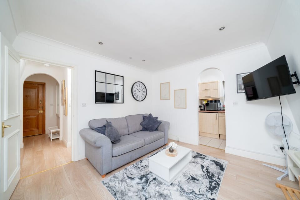 Cozy lounge area with a plush sofa and large smart TV for movie nights.