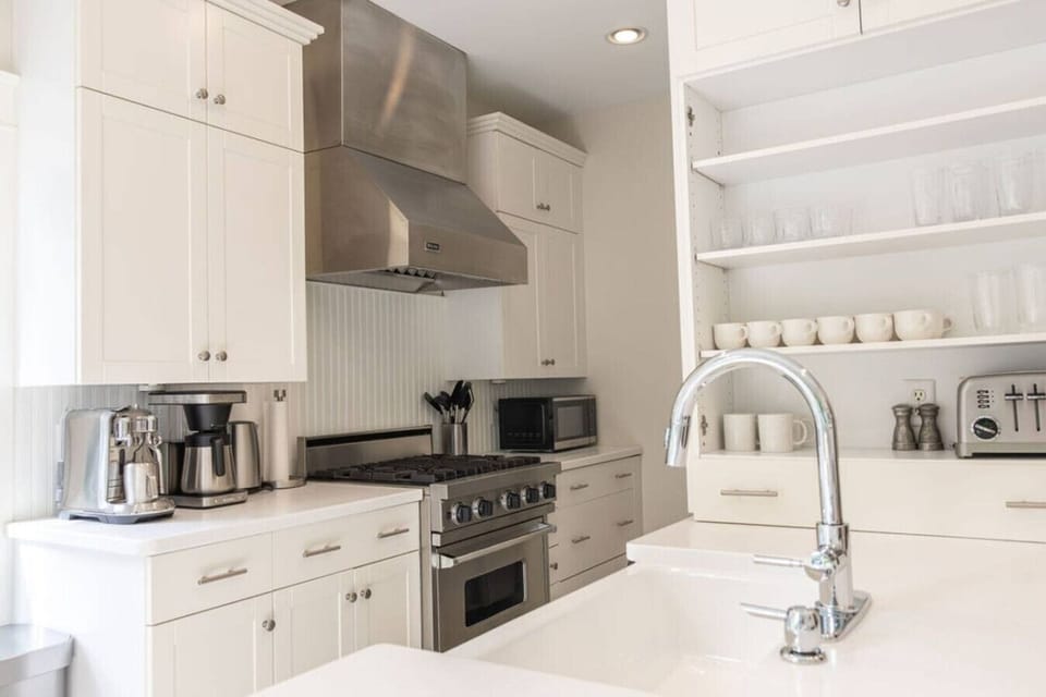 Chefs kitchen with Viking oven range and hood and utensils for cooking.