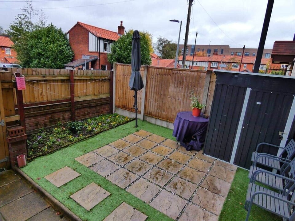 Private outdoor patio area at the front of the property, with garden furniture and parasol.