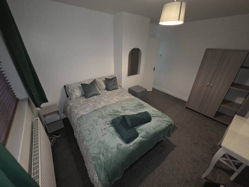 Master bedroom featuring double bed, dressing area, double wardrobe, and towels/blankets provided.