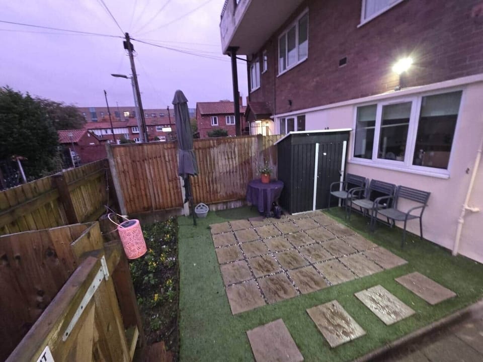 Private outdoor patio area at the front of the property, with garden furniture and parasol.