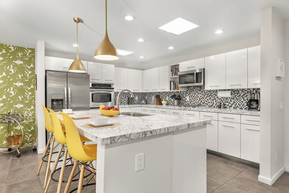 Kitchen with barstool seating and stainless steel appliances.