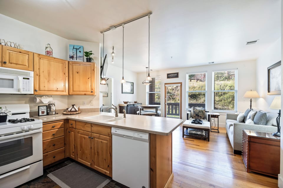 A well-equipped kitchen with natural wood finishes, full-size appliances, and bar seating that opens into the living area. Perfect for cooking meals while staying connected with family and friends.