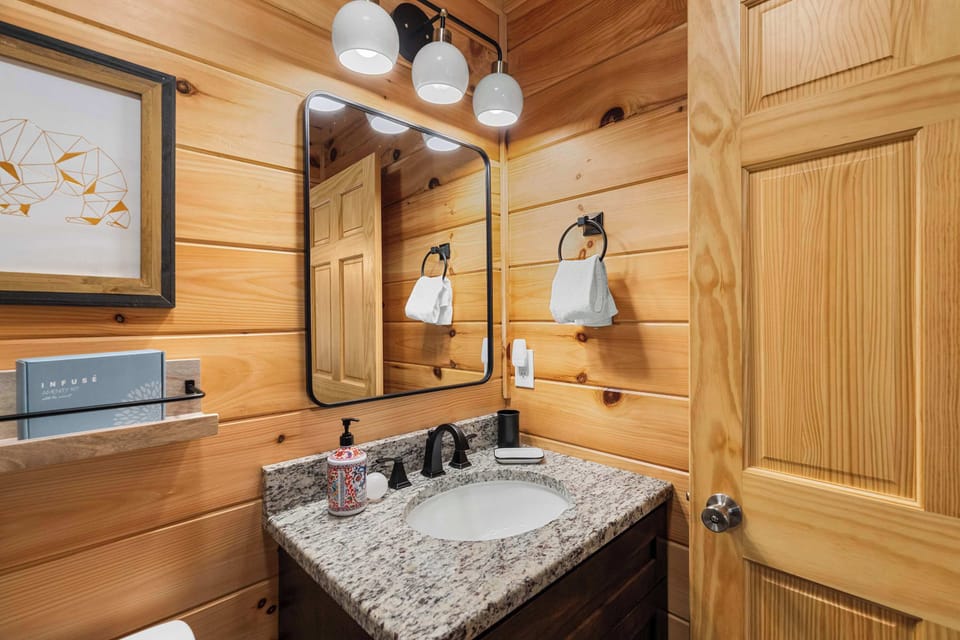 Your Bathroom Bliss awaits! Elegant granite vanity with stylish lighting and rustic wood details. Perfect for refreshment!