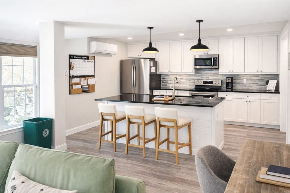 Functional and inviting kitchen featuring a spacious island with bar seating for three, stainless steel appliances, and modern finishes. We keep it stocked with coffee, teas, and basic spices so you can cook or grab a quick breakfast without hassle.