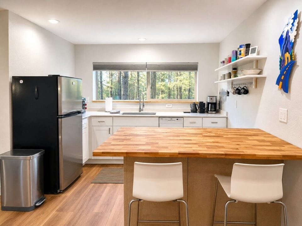 The well-equipped kitchen includes butcher block prep space for meals, coffee, or remote work.