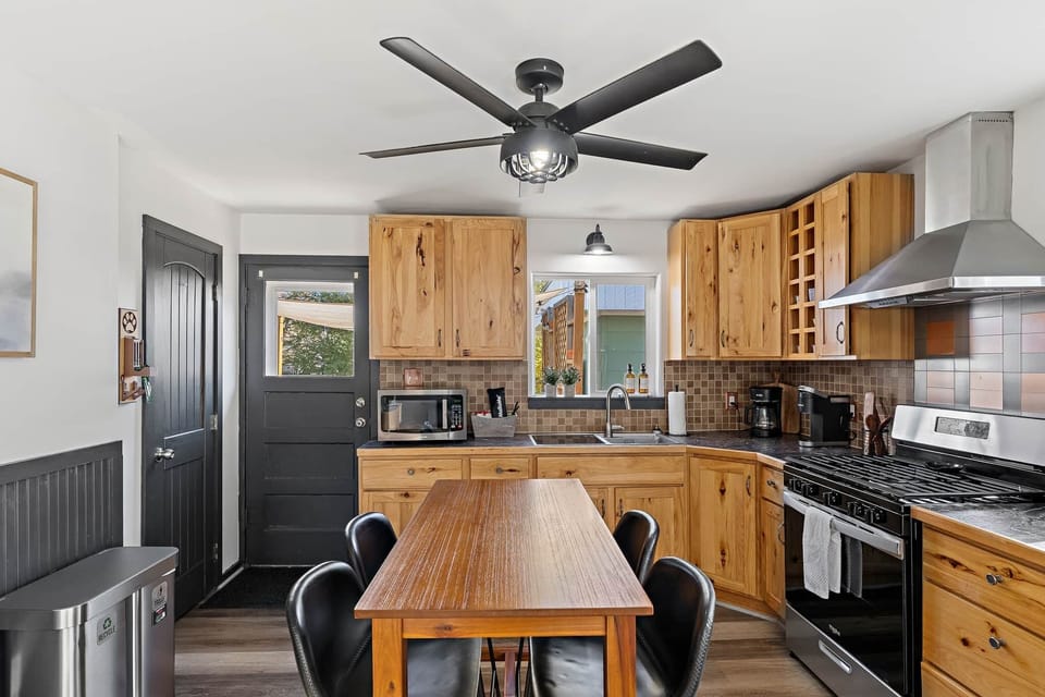 Modern kitchen with rustic cabinetry, a gas range, and a spacious dining area for group meals