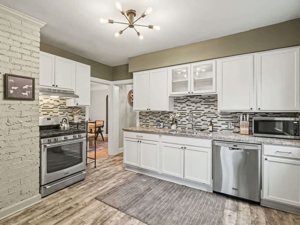 Modern Chef’s Kitchen Cook in style with sleek white cabinetry, stainless appliances, and chic sage accents. This bright, fully-equipped space features beautiful tile backsplashes and ample counter space for all your culinary needs.