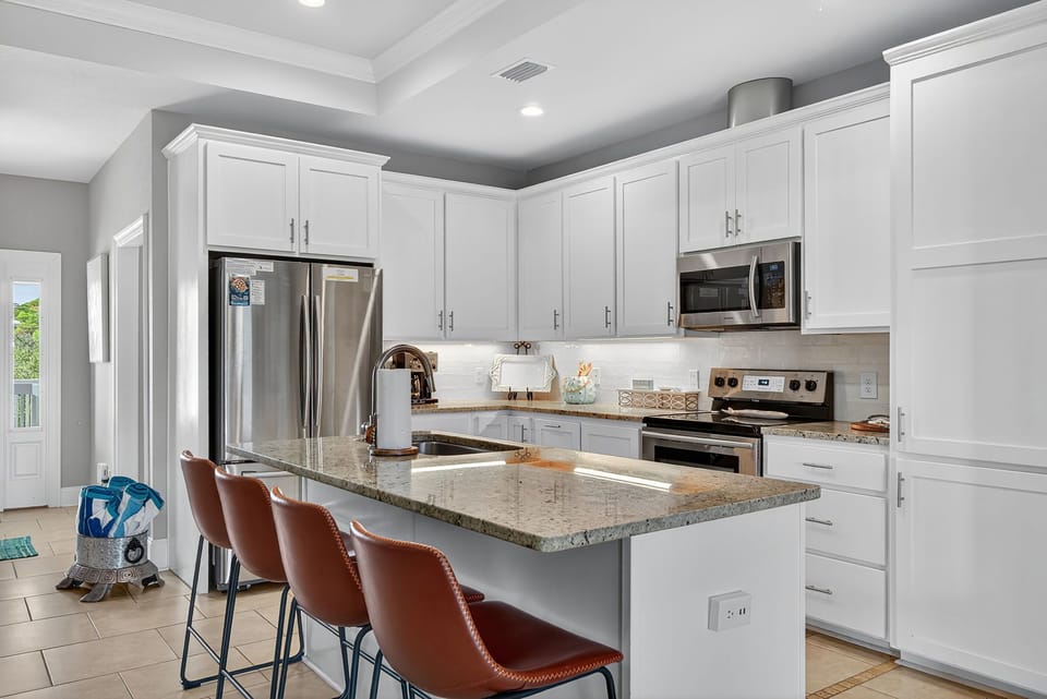 The kitchen is thoughtfully designed for both casual meals and culinary adventures. A large eat-in island anchors the space.