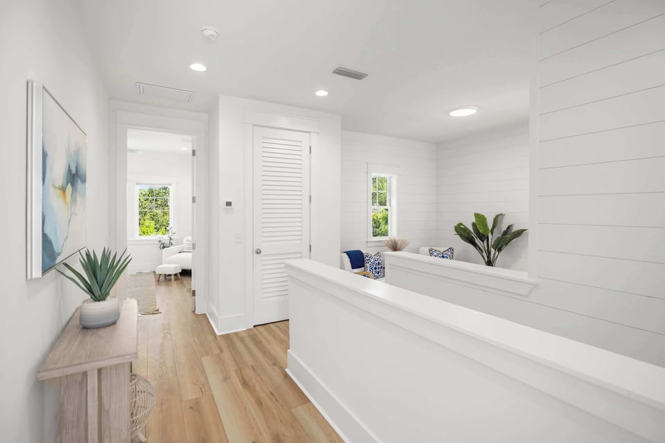 Bright hallway: with a small table, a painting, and a view into a cozy sitting area.