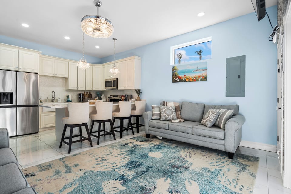 Open-concept living room and kitchen with modern appliances.