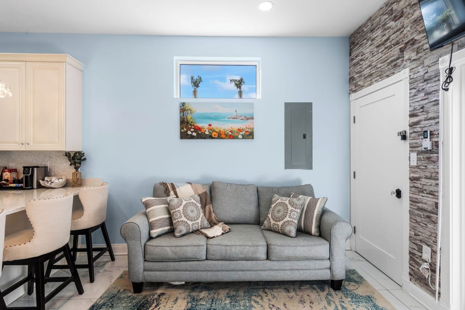 Cozy living room with wall-mounted TV and coastal wall art.