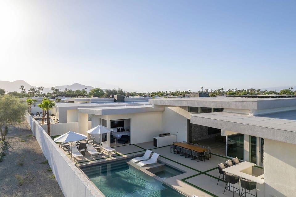 An elevated view showcasing the fully private backyard, pool, dining, and unobstructed mountain views on a clear day.
