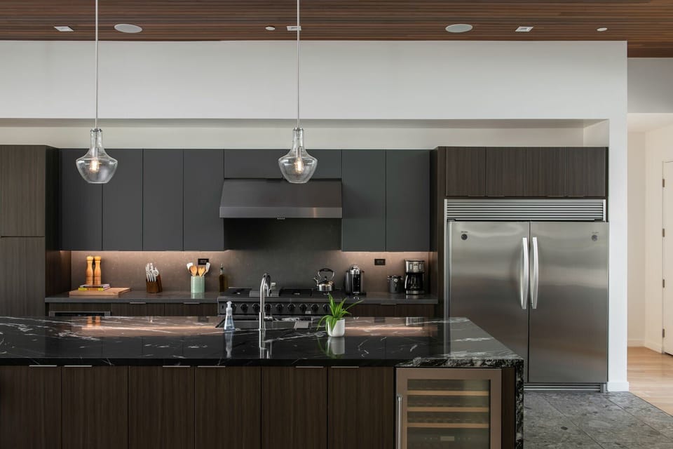 The gourmet chef's kitchen boasts a large marble island, professional stainless steel appliances, and a built-in wine fridge.