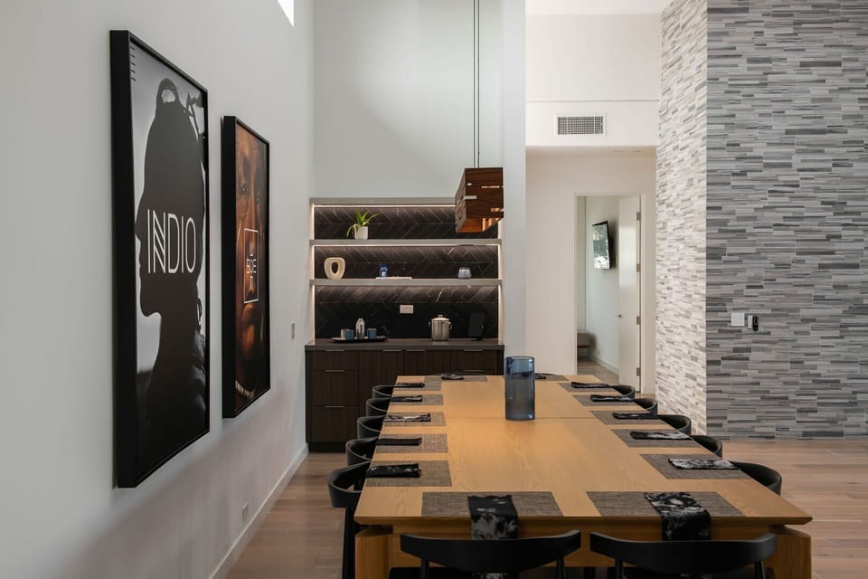 The formal dining area comfortably seating 10+, featuring striking Indio-inspired art and a convenient bar/coffee station.