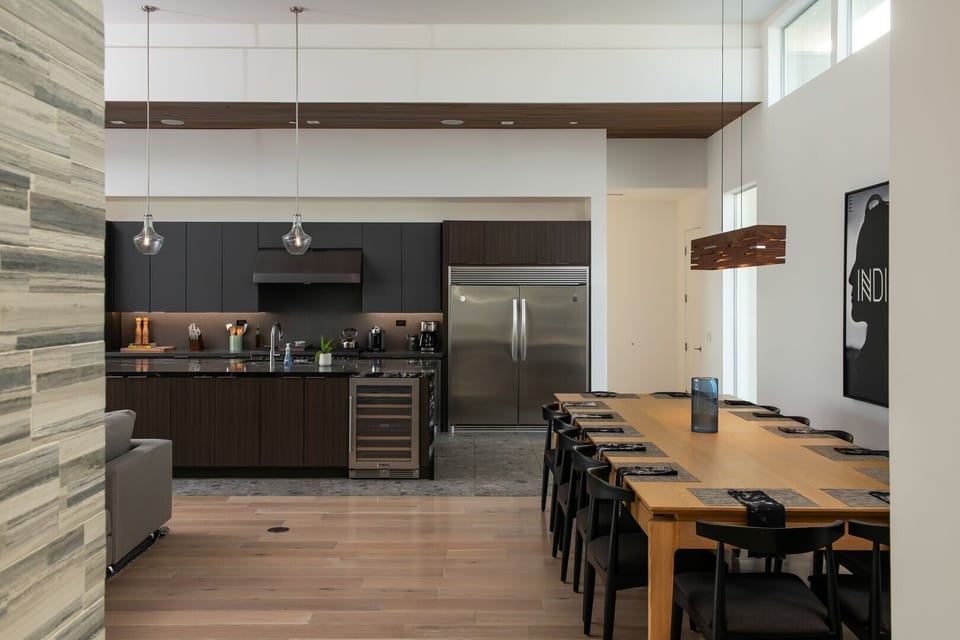 A clear view of the open-concept layout connecting the kitchen and the oversized dining table, perfect for large groups.