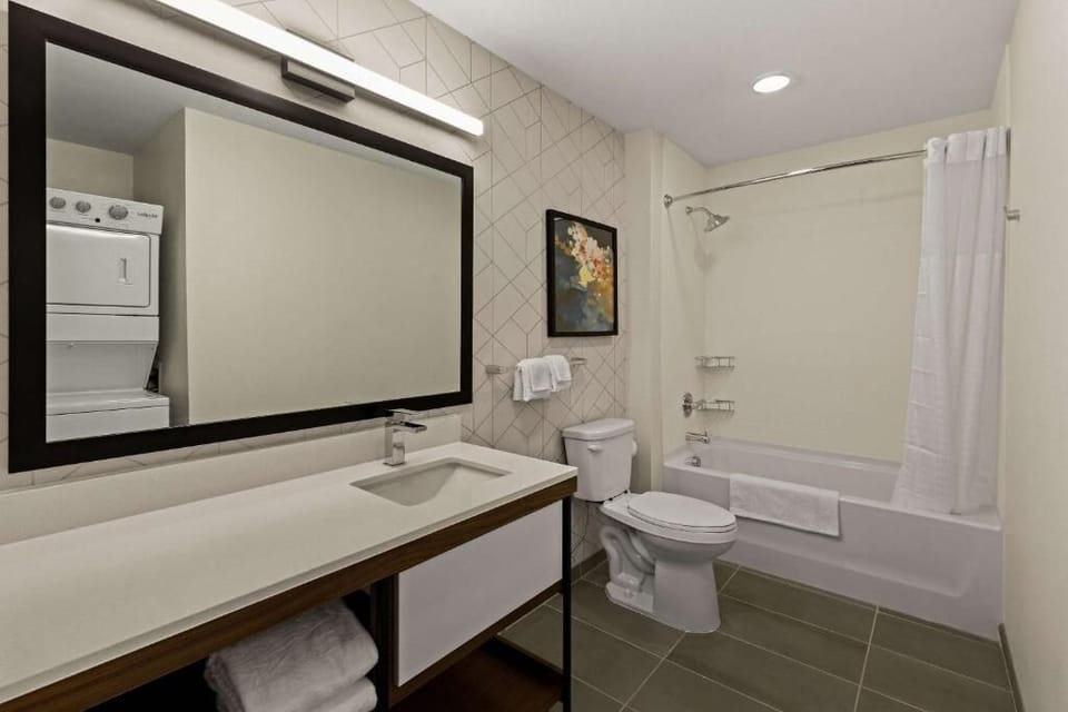 Refresh in a bright bath with tub-shower and fluffy towels.