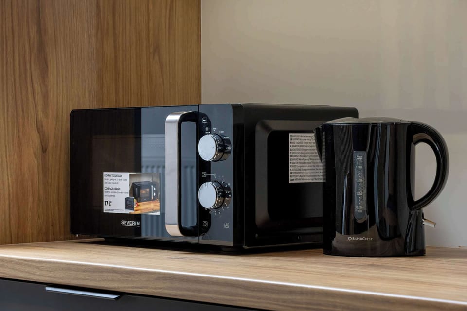 Kitchen countertop and coffee station – Includes microwave, electric kettle, and coffee maker for guests’ convenience.