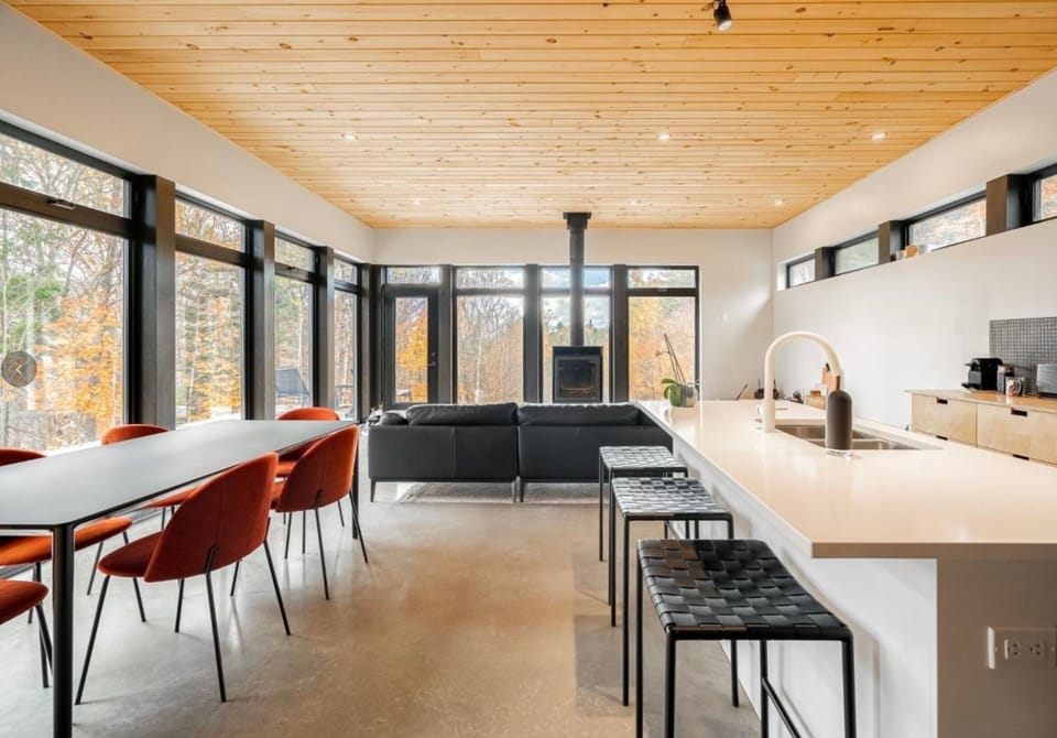 Cuisine moderne et salle à manger vitrée – un espace lumineux et ouvert sur la nature pour cuisiner et partager en toute simplicité