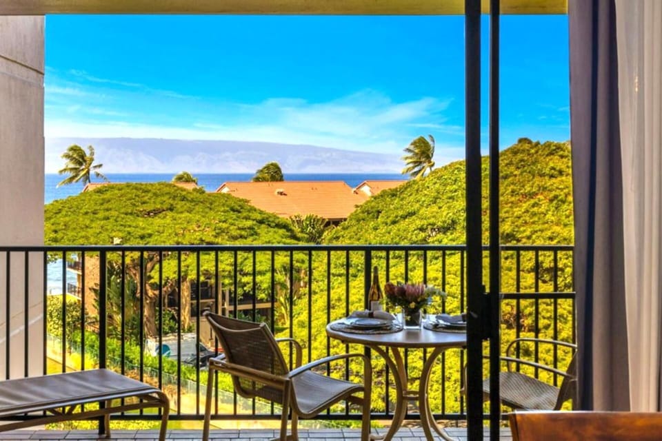 KS-616 Framed by floor-to-ceiling glass, this lanai invites you to dine with views of the Pacific and lush canopy below.