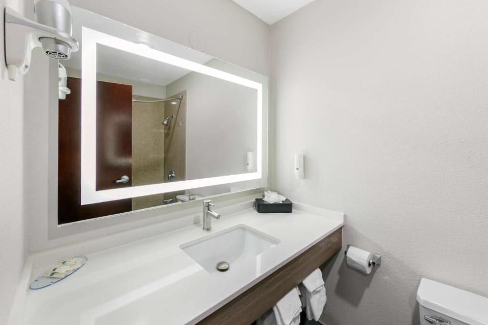 Freshen up with a sleek sink and illuminated mirror glow.